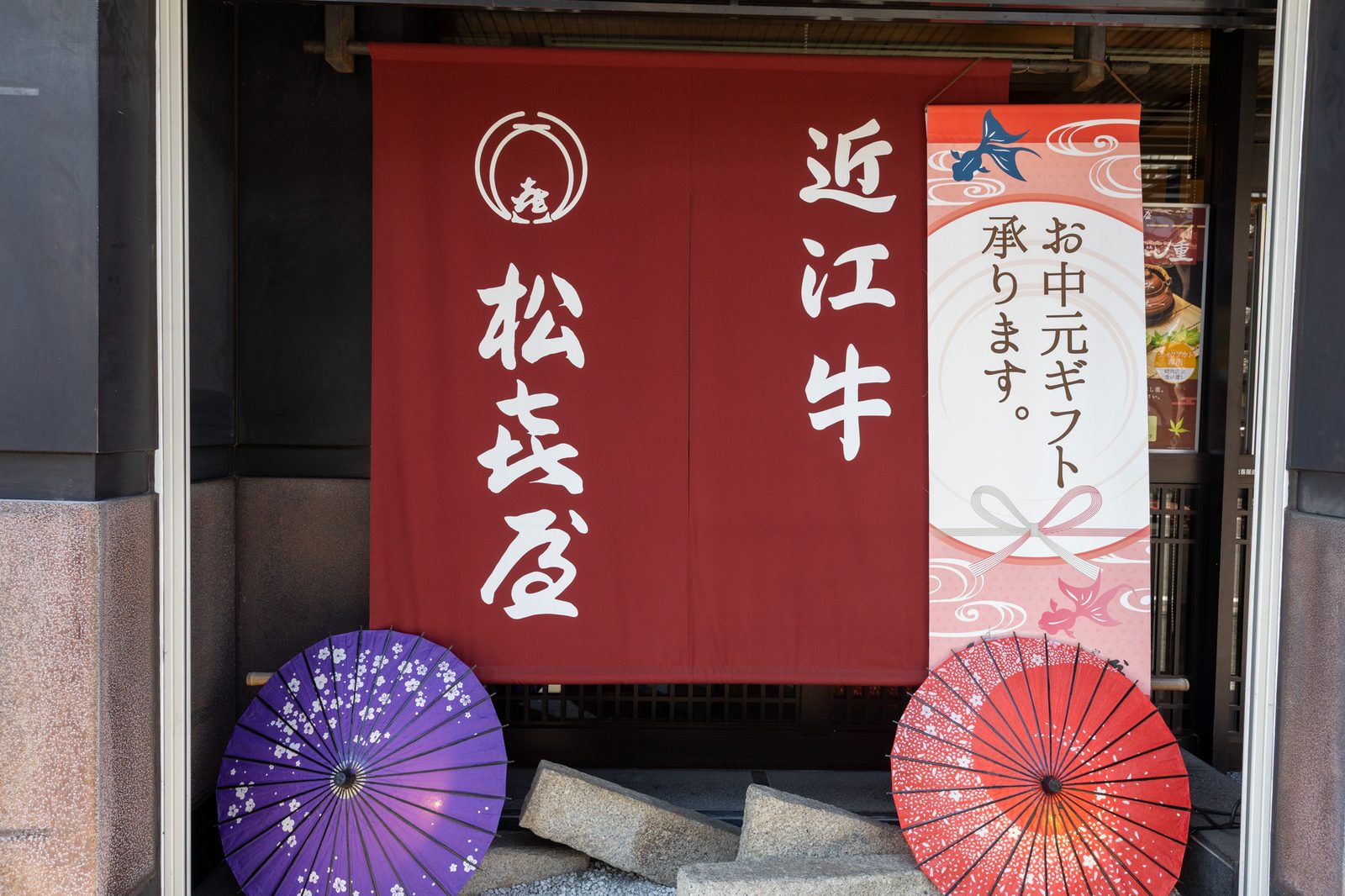 赤い暖簾と和傘の店先